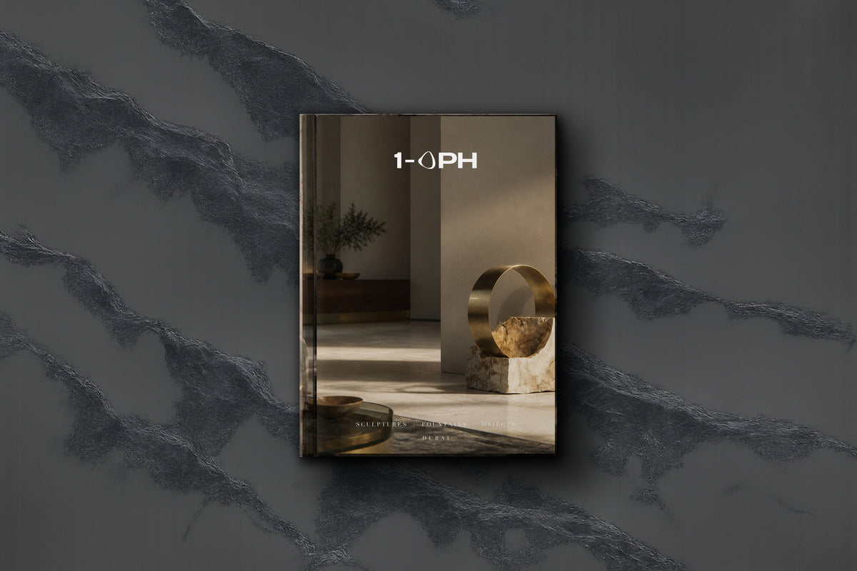 A striking mixed-material sculpture combining cool marble and warm bronze in a calm Gulf interior, contrast doing the work