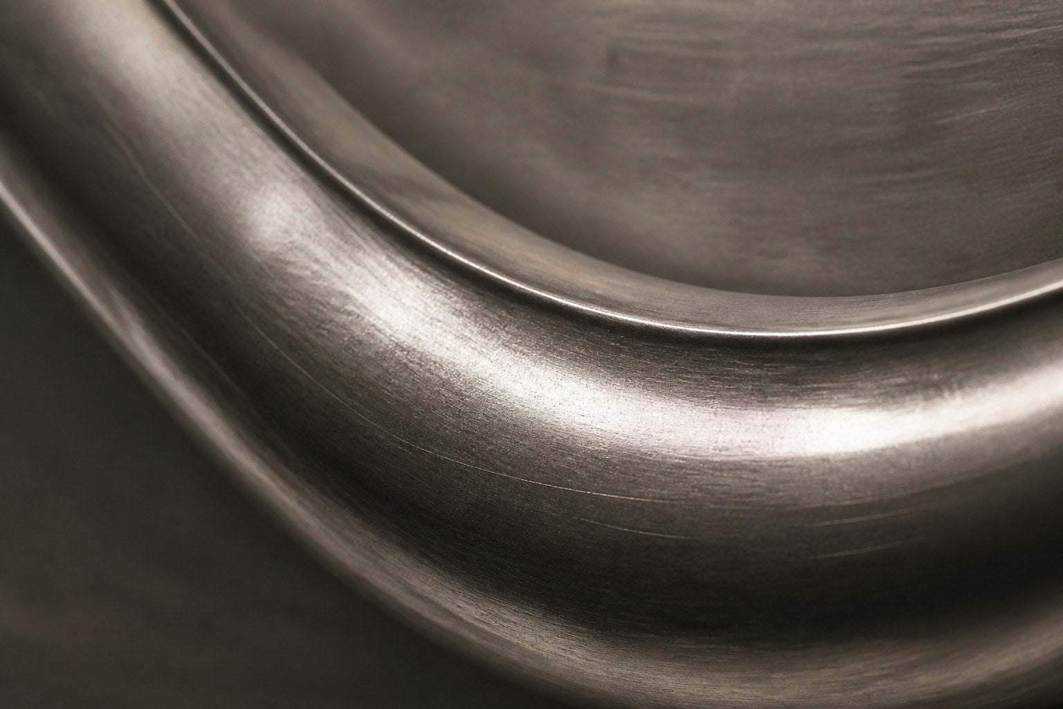 Polished pewter waveform in relief on a dark graphite panel with a pale frame.