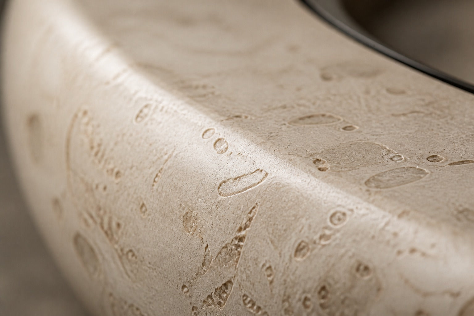 Pale fossil travertine fire bowl Bruna Ø180, pale cream with dense fossil shell, on a pale stone floor.