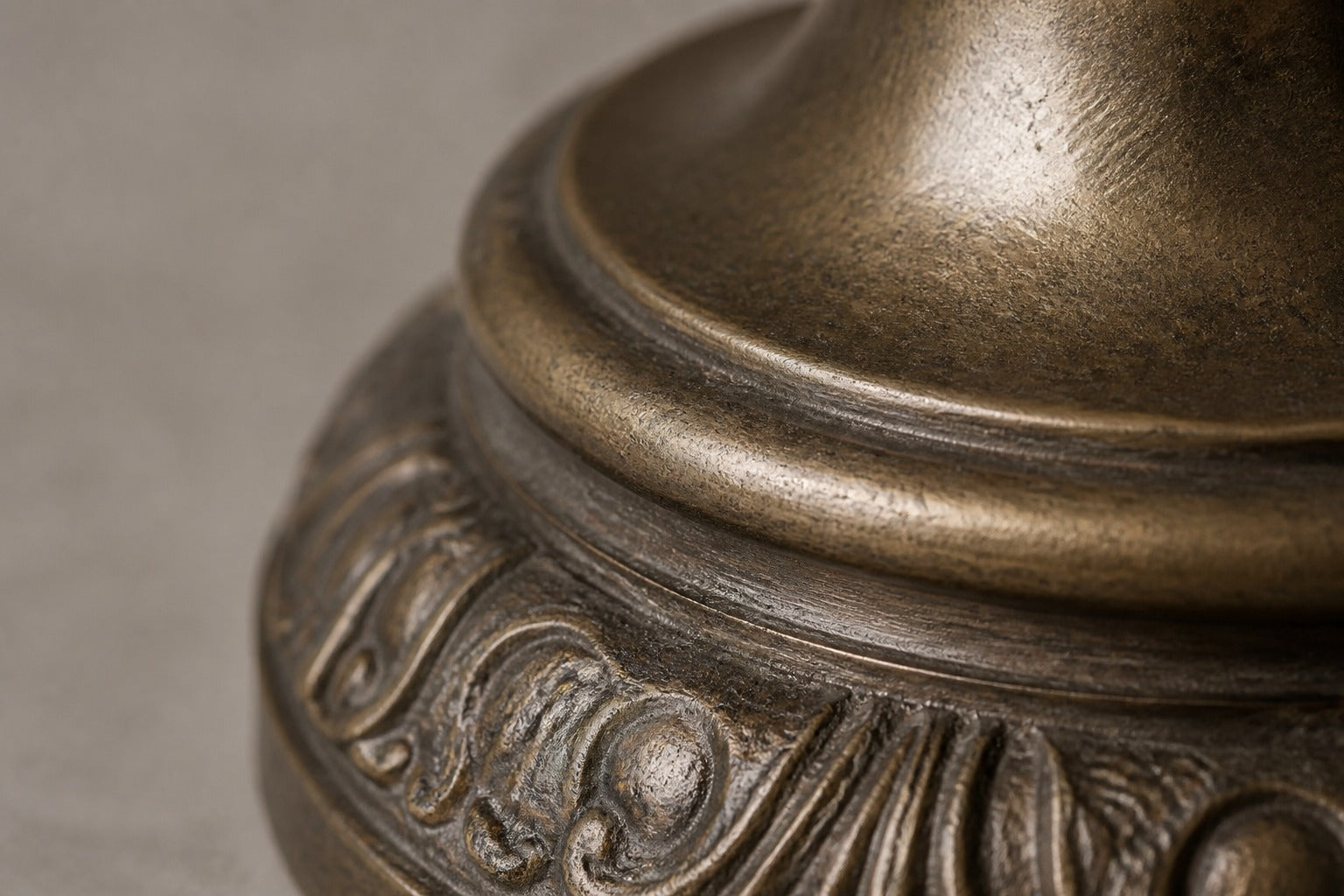 Stone pedestal fountain Cascina Ø65, antique bronze with olive depths, on a pale stone floor.