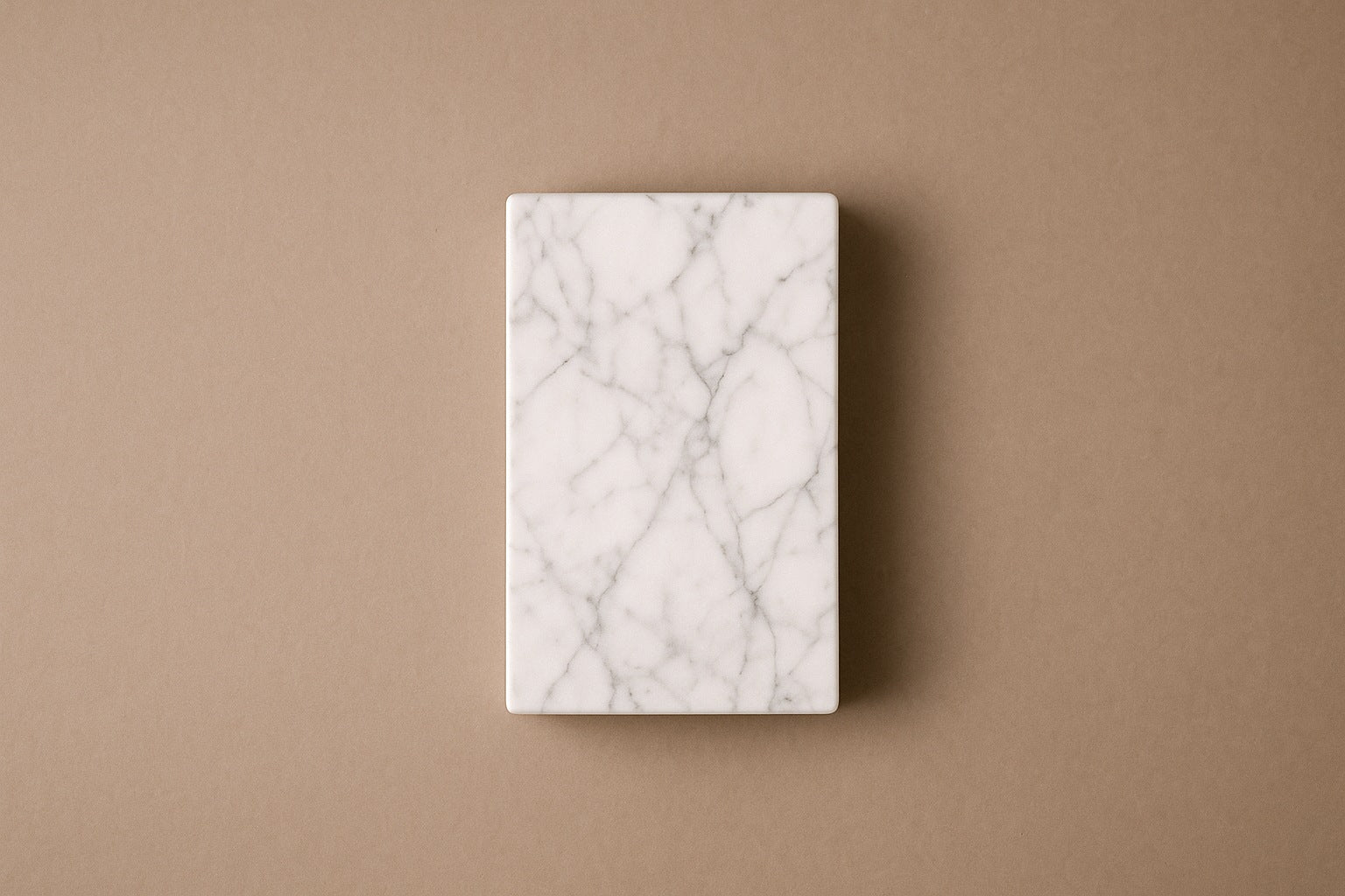 Tall white Carrara marble column carved into a grid of raised cushioned panels.