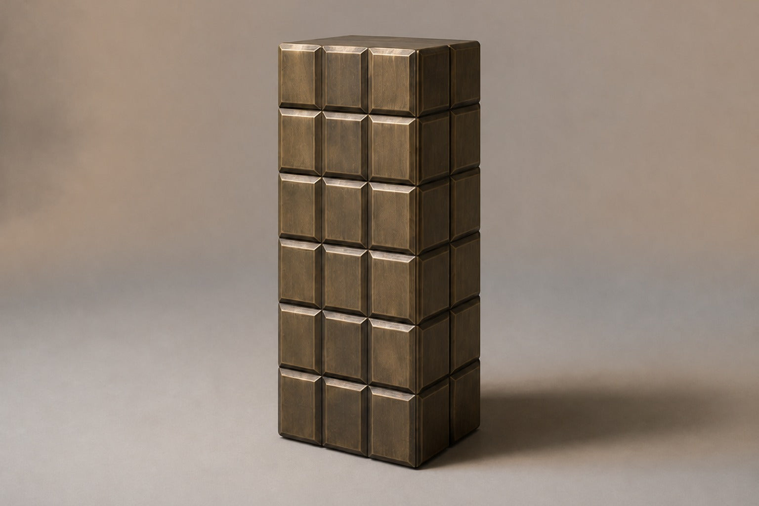 Tall antique bronze column built as a grid of raised cushioned panels.
