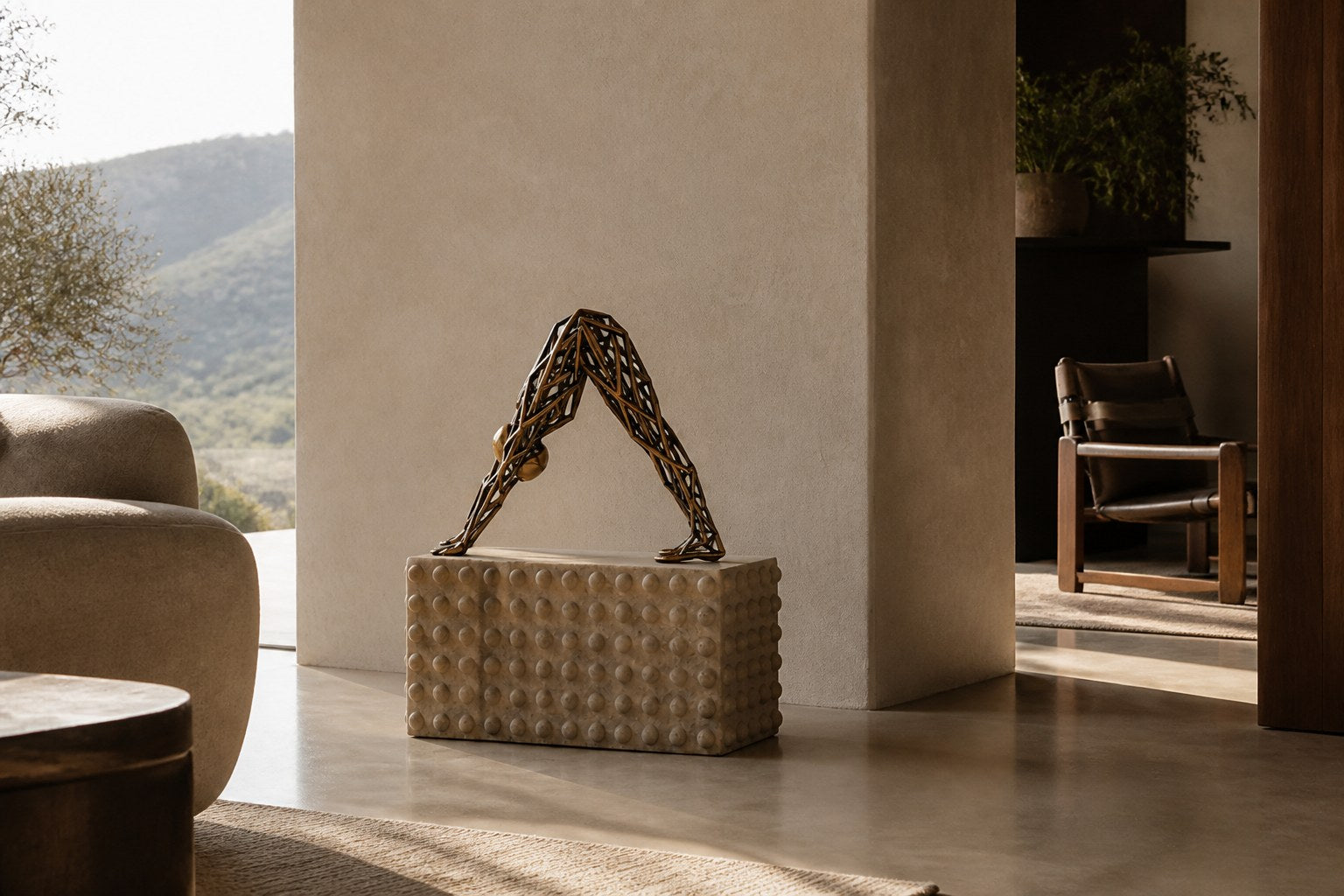 Bronze strut-cage sculpture Sbalzo forming an inverted arch, gilt and blackened, on a beaded travertine block.