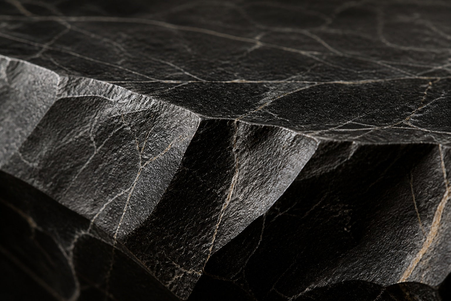 Black basalt fire table Tsukage 220, dense black with fine grey veining, on a pale stone floor.