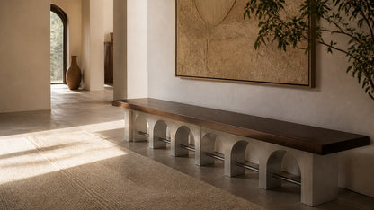 Stone bench Descanso 240, warm walnut seat, pale stone arcade, on a pale stone floor.