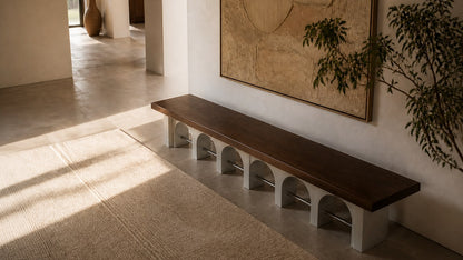 Stone bench Descanso 240, warm walnut seat, pale stone arcade, on a pale stone floor.
