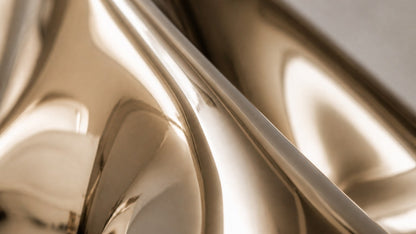 Bronze bench Raha 150, warm polished bronze, on a pale stone floor.