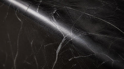 Black stone bench Yutori 180, deep black with white veining, on a pale stone floor.