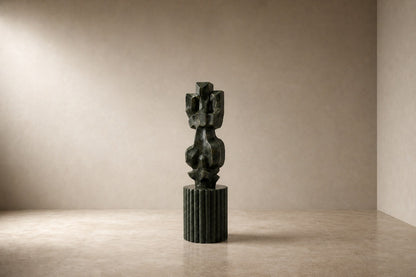 Deep green marble sculpture Almach, a column of stacked interlocking carved blocks on a fluted green marble drum plinth.