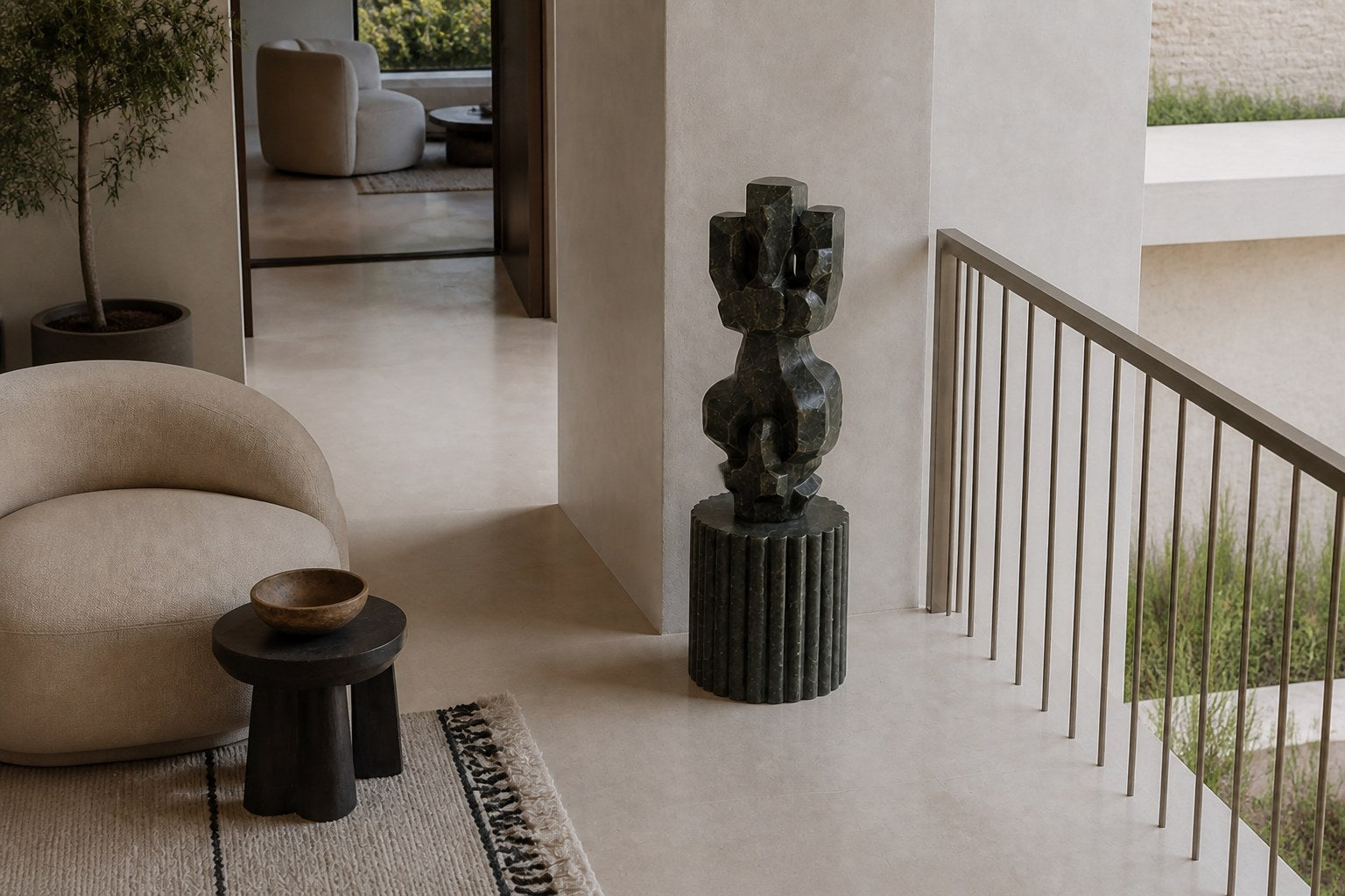 Deep green marble sculpture Almach, a column of stacked interlocking carved blocks on a fluted green marble drum plinth.
