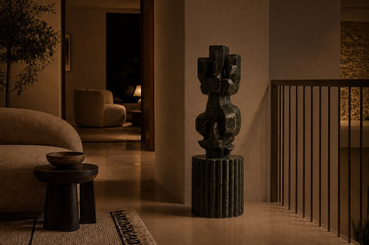 Deep green marble sculpture Almach, a column of stacked interlocking carved blocks on a fluted green marble drum plinth.