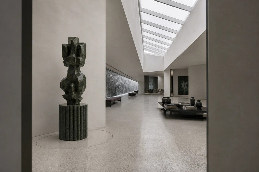 Deep green marble sculpture Almach, a column of stacked interlocking carved blocks on a fluted green marble drum plinth.