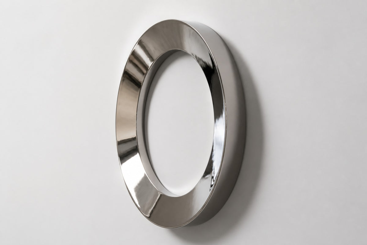 Aro — Ø 160 cm mirror-polished stainless steel ring wall sculpture, studio side angle showing its depth