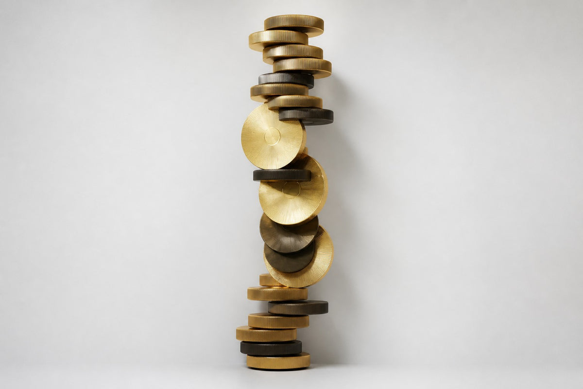 Atalaya — tower of stacked brass and bronze discs with two upright gold suns, studio front view