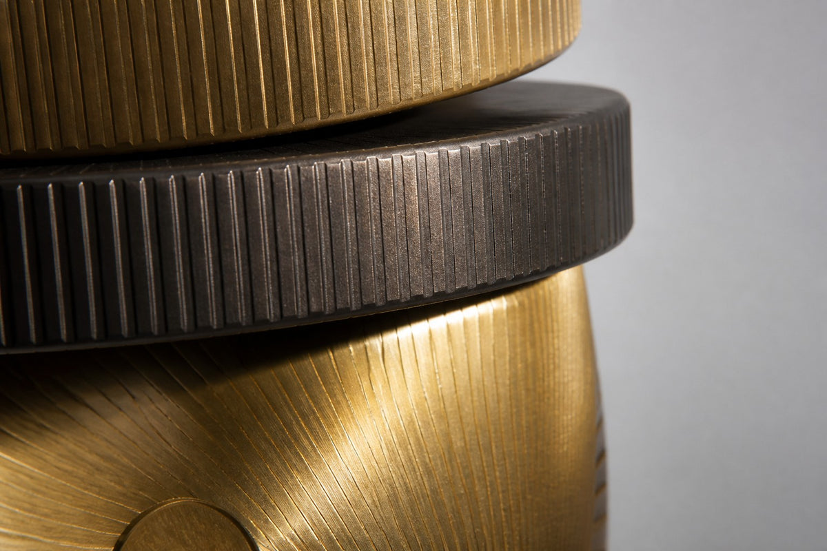 Atalaya — tower of stacked brass and bronze discs with two upright gold suns, close detail of the surface and edge