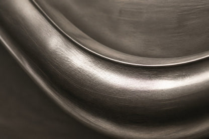 Polished pewter waveform in relief on a dark graphite panel with a pale frame.