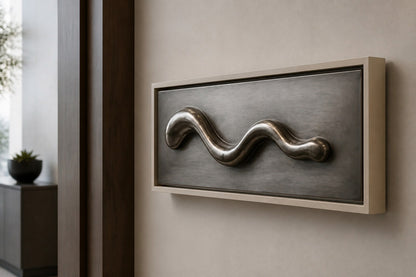 Polished pewter waveform in relief on a dark graphite panel with a pale frame.