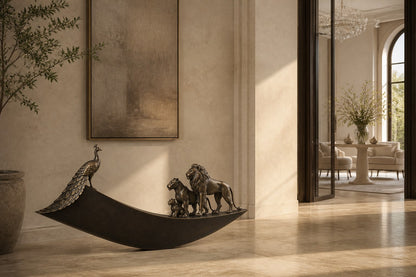 Warm bronze crescent sculpture Barranco balanced on its curve, a standing group at one end and a single raised figure at the other.
