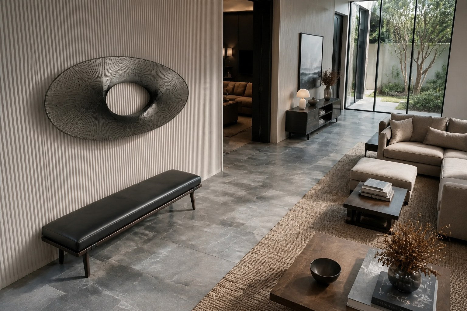 Broad woven-wire ellipse in pale grey with an open oval void, against a plaster wall.