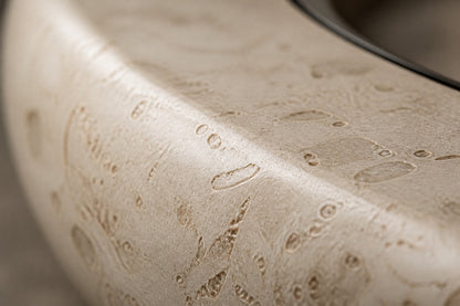 Pale fossil travertine fire bowl Bruna Ø180, pale cream with dense fossil shell, on a pale stone floor.