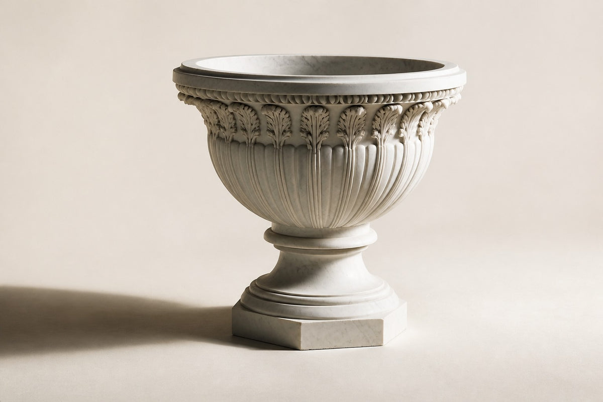 Carrara Acanthus Classical Marble Urn Planter — 90 cm white Carrara marble urn planter with a carved acanthus-leaf frieze on an octagonal plinth, three-quarter studio view showing its profile
