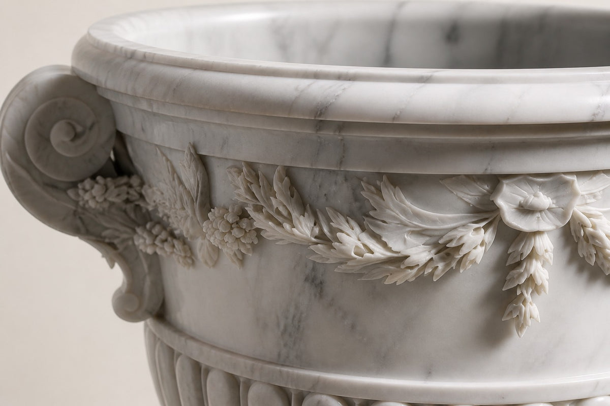 Carrara Floral Garland Marble Urn Planter — 95 cm white Carrara marble urn planter with a carved floral garland and two scroll handles, close studio detail of the surface and material