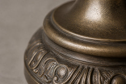 Stone pedestal fountain Cascina Ø65, antique bronze with olive depths, on a pale stone floor.