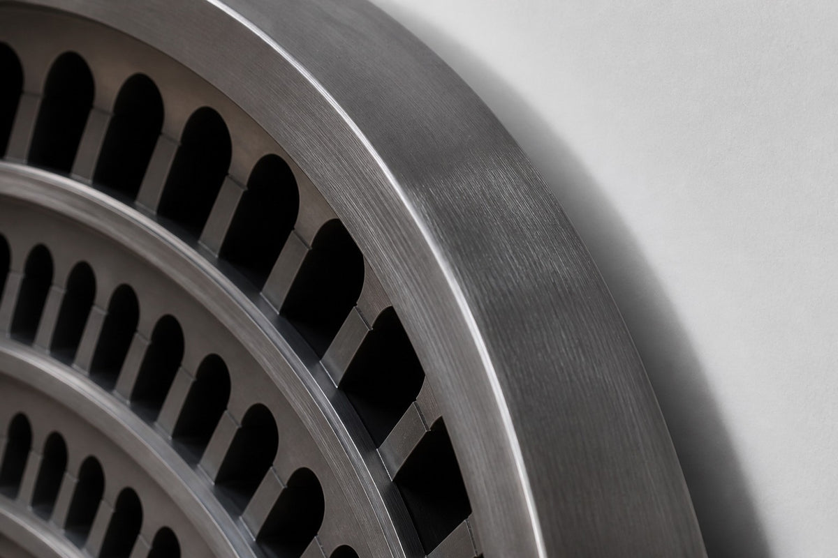 Cavea — 200 × 14 cm gunmetal oval wall relief of concentric rings of arched openings, close studio detail of the surface and material