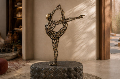 Bronze strut-cage figure sculpture Cesello in arabesque with arm extended, on a dark quilted stone block.