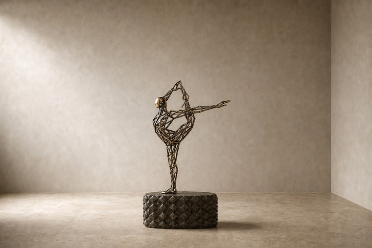 Bronze strut-cage figure sculpture Cesello in arabesque with arm extended, on a dark quilted stone block.