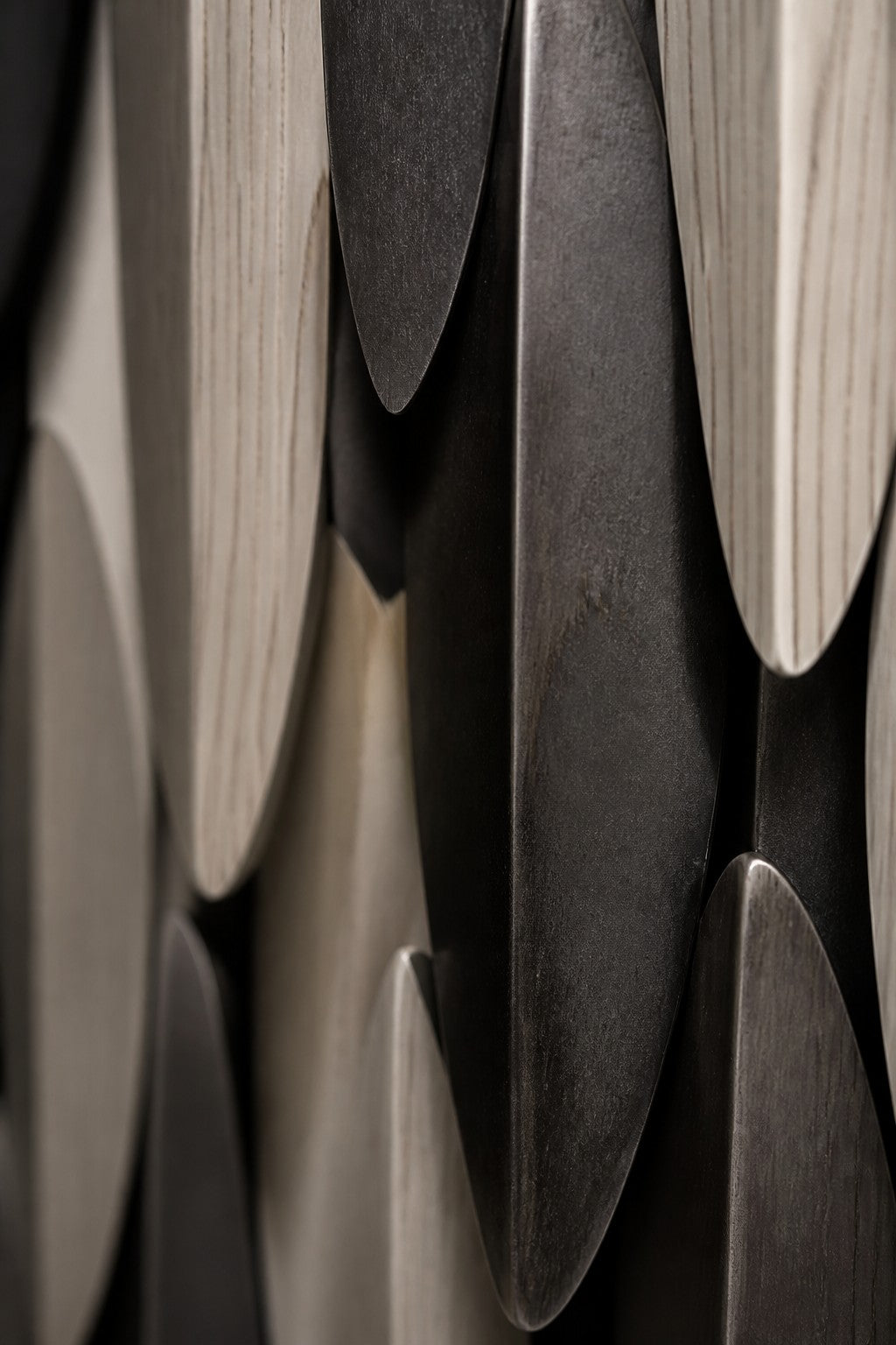 Cumulo — 85 × 150 cm tall oval wall sculpture of black, gold and white plates, close studio detail of the surface and material