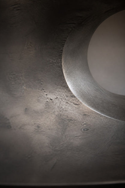 Gunmetal with bright edges bronze wall sculpture Scalino, graduated blades stepped across a concealed spine, on a plaster wall.