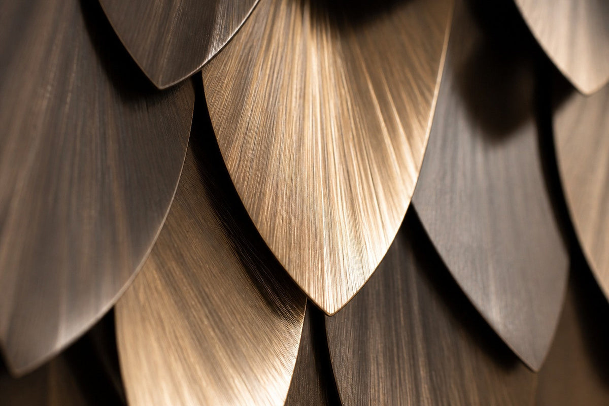 Dhahab — 200 × 70 cm long brass wall panel of overlapping leaf-shaped scales, close studio detail of the surface and material