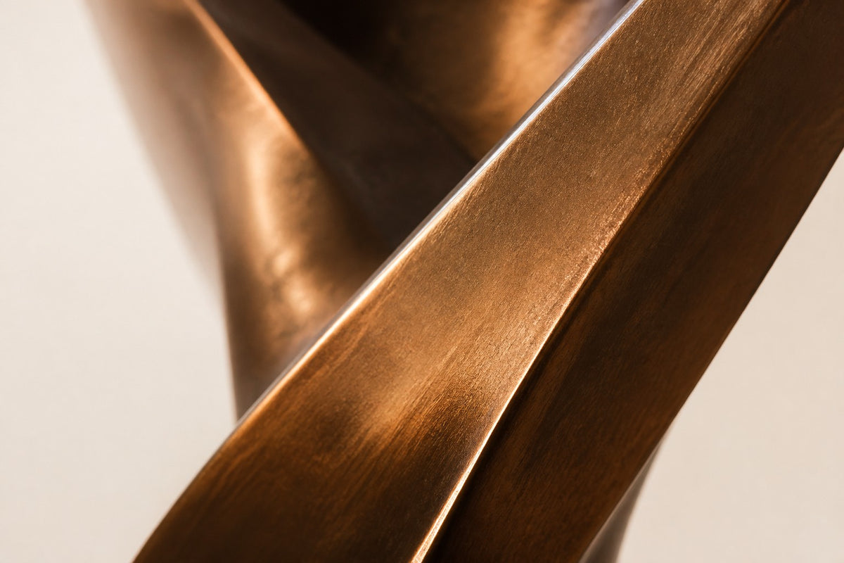 ETERNAL FLUX — 250 cm polished bronze sculpture of a twisting ribbon rising into an open loop, close studio detail of the surface and material