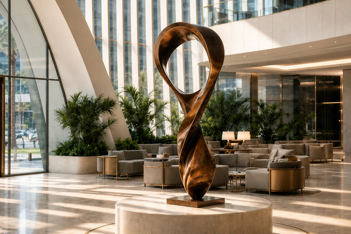 ETERNAL FLUX — 250 cm polished bronze sculpture of a twisting ribbon rising into an open loop, close view in the room