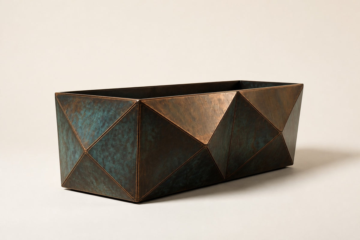 Facet Planter — 45 cm faceted trough planter with triangular copper and verdigris-patina panels, three-quarter studio view showing its profile