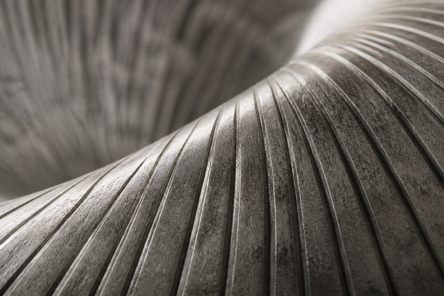 Elliptical woven-wire form twisting into a saddle, in charcoal and silver-grey.