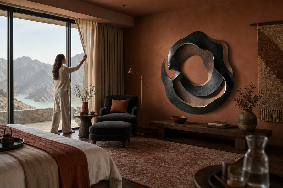 Figura — bronze and copper circular wall sculpture with a woman's profile, installed on the wall of a furnished room