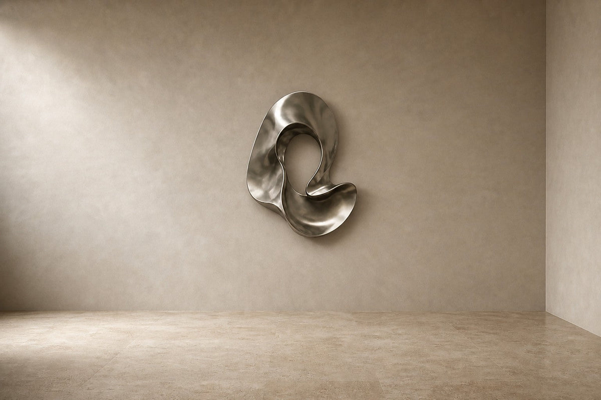 Fluente — 110 × 120 cm polished steel wall sculpture of a folded flowing ribbon, studio view of the whole piece