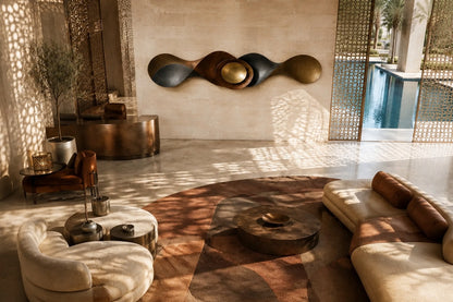 Long undulating bronze ribbon with a nested bowl and polished gold dome at its centre.