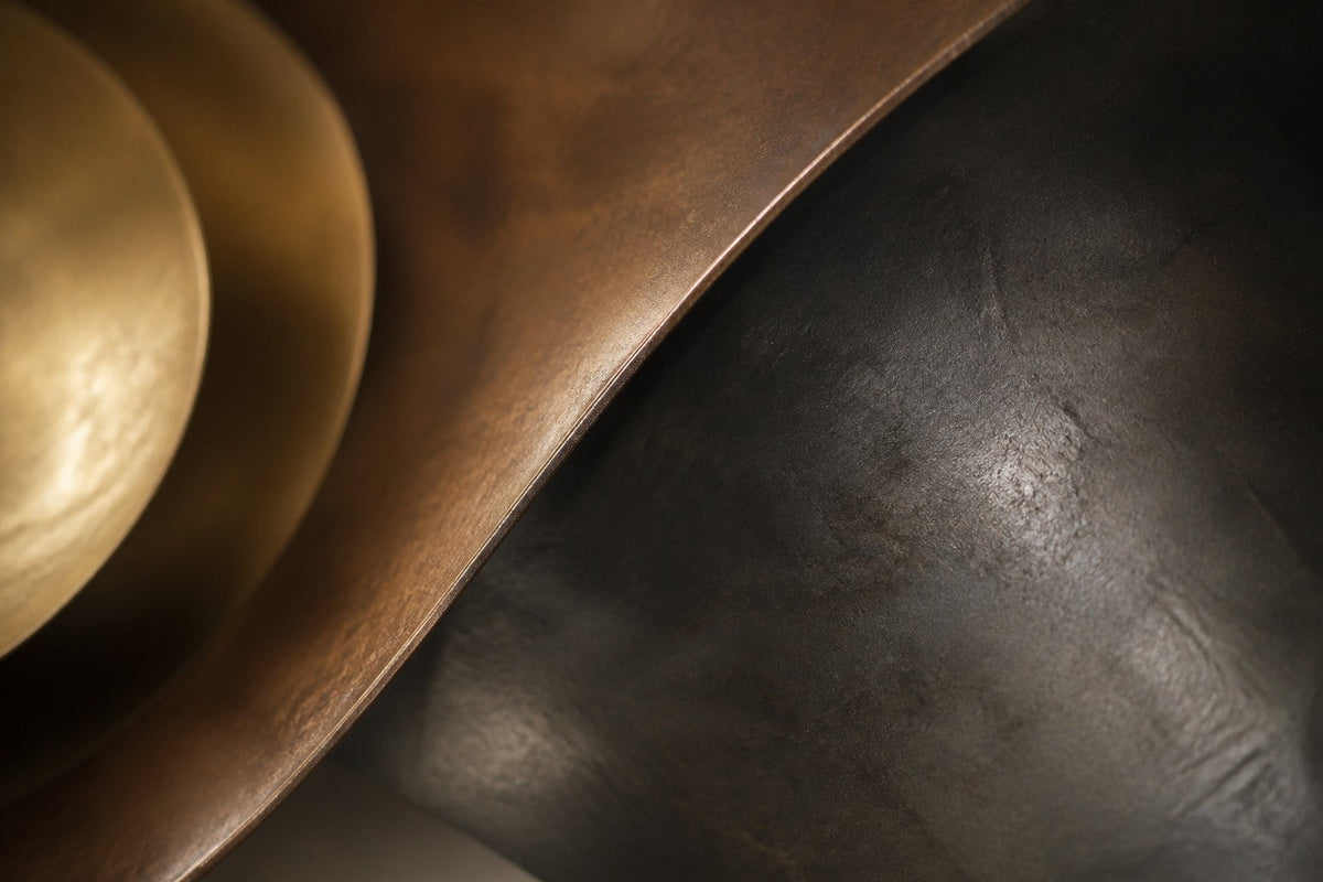 Flusso — 210 × 55 cm bronze wall sculpture of a twisting ribbon with a gold centre, close studio detail of the surface and material