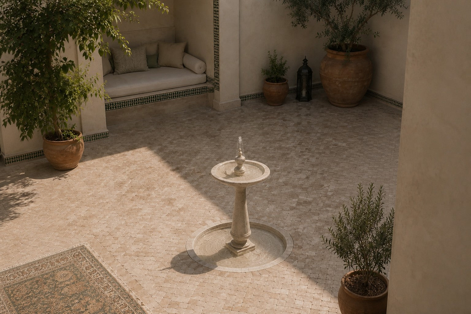 Pale limestone pedestal fountain Fontena Ø65, cream with open fossil speckle, on a pale stone floor.