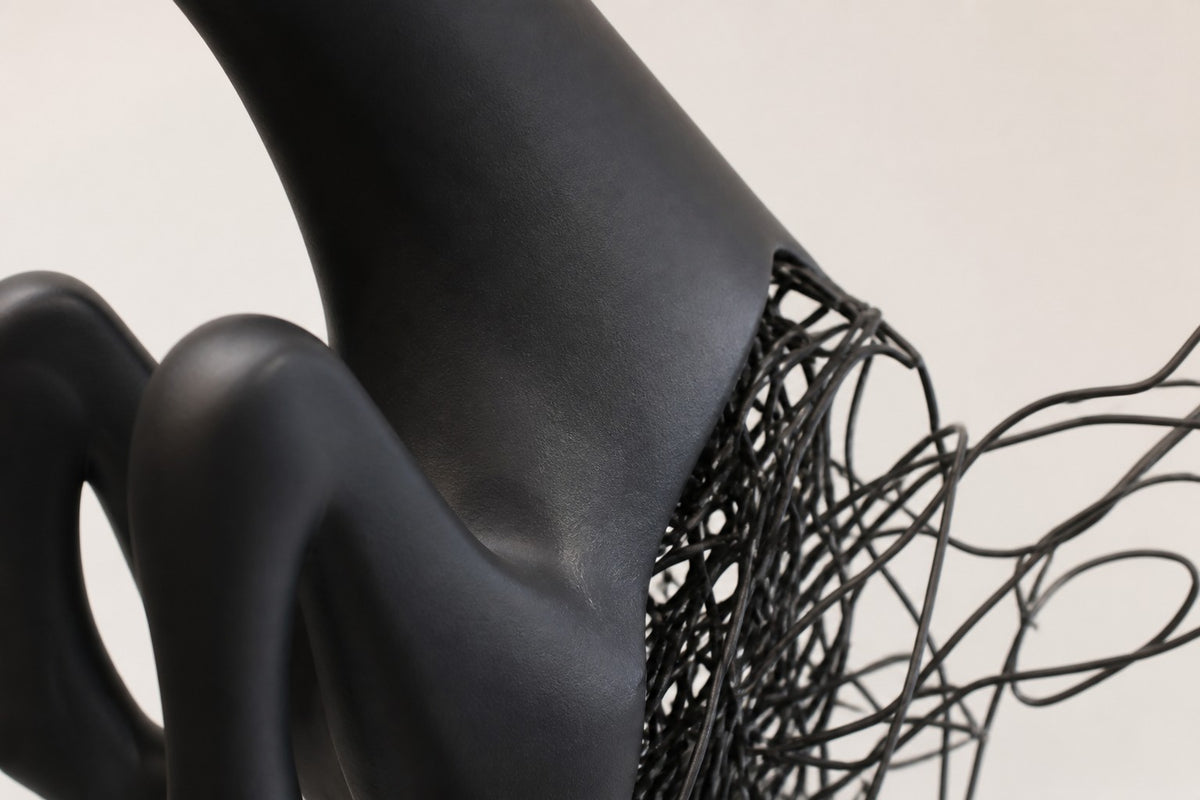 Ghazal — matte black stainless steel leaping antelope sculpture, close detail of the surface and edge