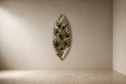 Olive green and dark bronze bronze wall sculpture Ramoscello, cast branch with individually mounted leaves and fruit, on a plaster wall.
