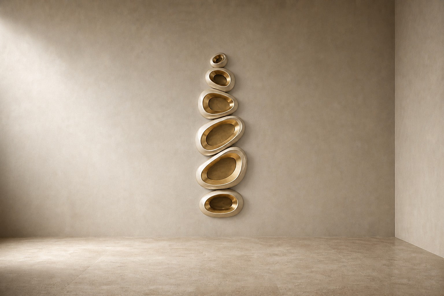 Champagne gold bronze wall sculpture Guijarro, a continuous folded ribbon swelling to a smooth belly, on a plaster wall.
