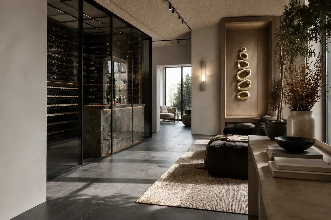 Champagne gold bronze wall sculpture Guijarro, a continuous folded ribbon swelling to a smooth belly, on a plaster wall.