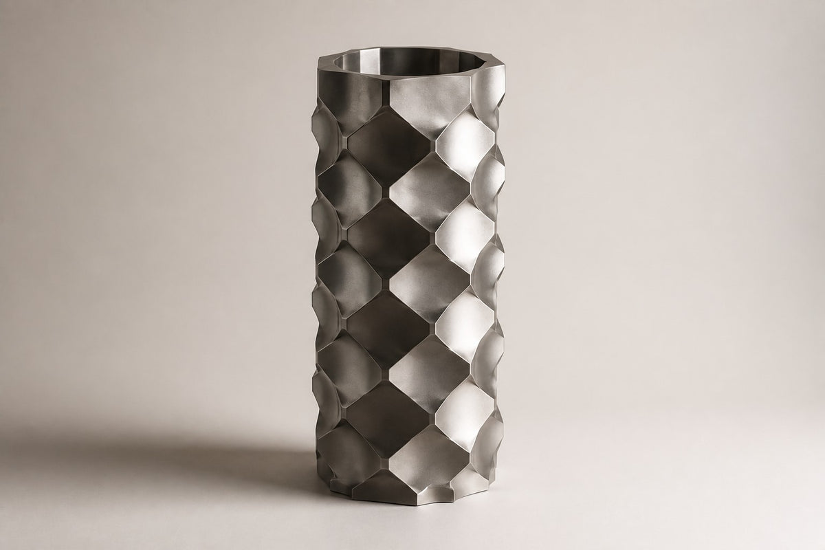 HexaFacet Stainless Steel Luxury Column Planter — 110 cm brushed stainless steel column planter with faceted honeycomb panels, three-quarter studio view showing its profile