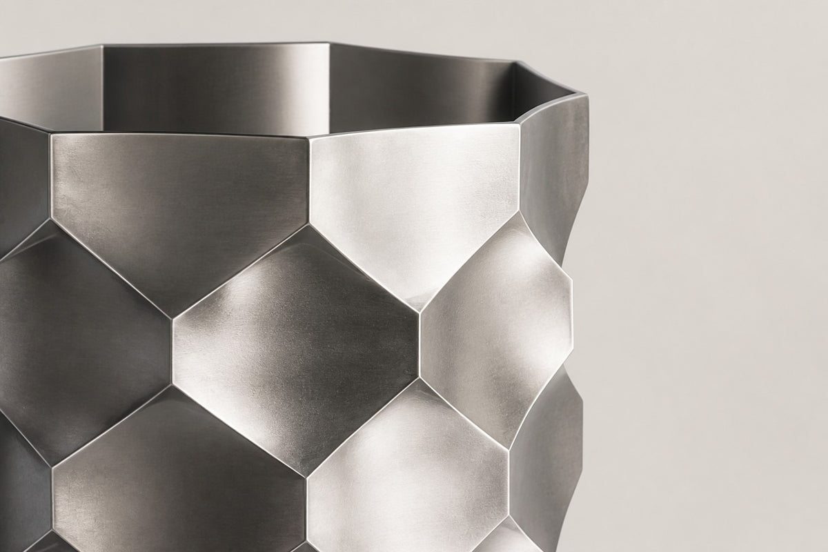HexaFacet Stainless Steel Luxury Column Planter — 110 cm brushed stainless steel column planter with faceted honeycomb panels, close studio detail of the surface and material