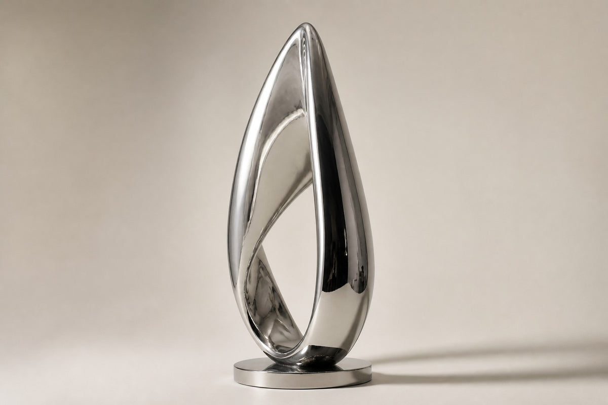 Hikari — mirror-polished stainless steel teardrop loop sculpture, studio side angle showing its depth