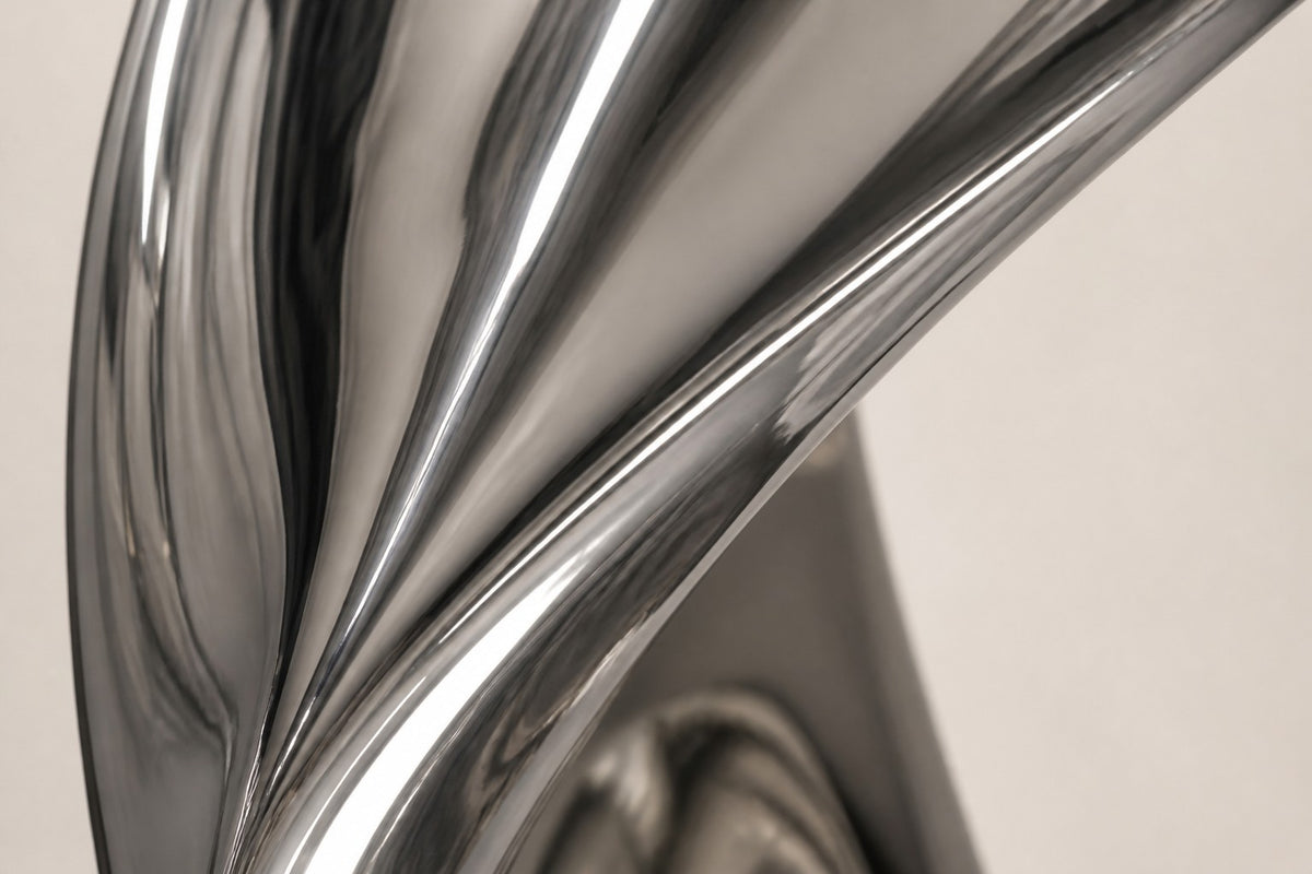 Hikari — mirror-polished stainless steel teardrop loop sculpture, close detail of the surface and edge